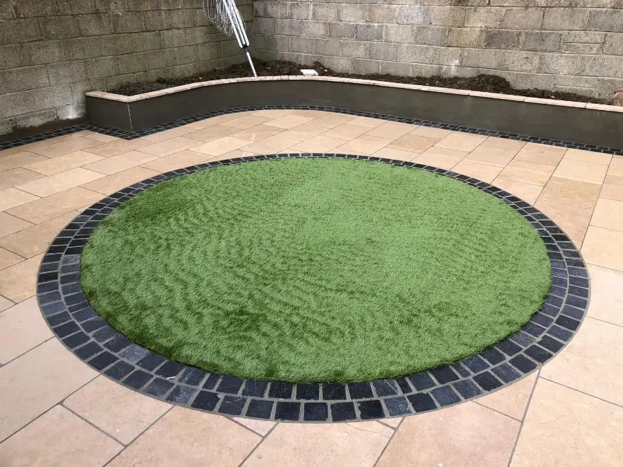 A circular lawn set into a Dublin patio with contrasting cobble edging
