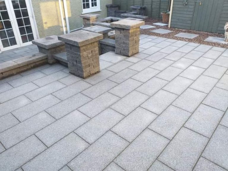 A granite patio with built-in seating pillars in a Dublin garden