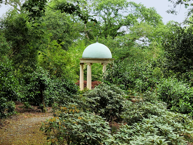The pale domed Temple among trees and shrubs at Mount Congreve Gardens