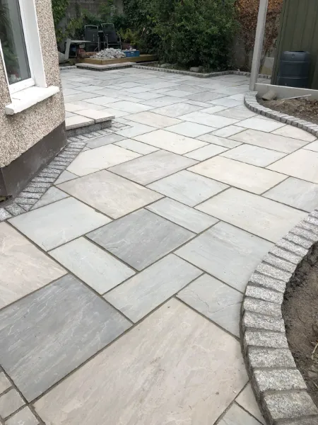 An Indian sandstone patio with granite cobble edging in an Irish back garden